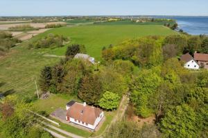 an aerial view of a house on a hill next to the ocean at LF10211-Thyholm-Ronbakken-11 in Thyholm