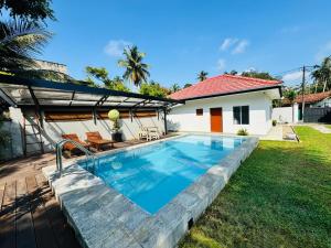 a swimming pool in a yard next to a house at Villa Wansha in Ratgama Hegoda