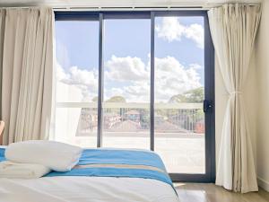 a bed in a room with a large window at Auburn Studio, Entire Studio with Ensuite toilet and kitchen in Sydney