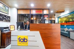 a woman sitting at a desk with a laptop at FabHotel Prakash & Sons, Hoshangabad Rd in Somarda Kauasot