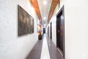 a hallway of a building with paintings on the walls at FabHotel Prakash & Sons, Hoshangabad Rd in Somarda Kauasot