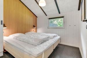 a bed in a room with a window at BV383-Blavand-Toldbodvej-34 in Blåvand