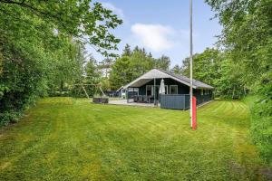 a large yard with a house with a playground at BV383-Blavand-Toldbodvej-34 in Blåvand