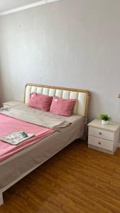 a bedroom with a bed with pink pillows and a table at 2 bed apartment in Buural
