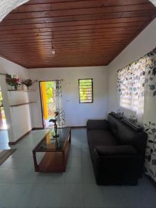 a living room with a couch and a table at La maison jaune in Nosy Be