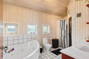 a bathroom with a tub and a toilet and a sink at FY237-Otterup-Vestparken-6 in Otterup +29 photos