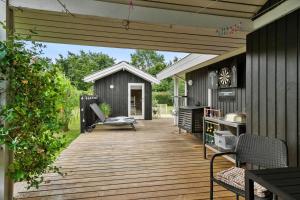 a wooden deck with a bench and a shed at FY237-Otterup-Vestparken-6 in Otterup