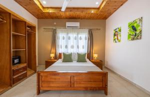 a bedroom with a bed and a window at Maison Ed-Elle in La Digue