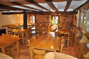 a restaurant with wooden tables and chairs and windows at La Cuculla in Ezcaray