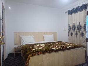 a bedroom with a bed with a wooden headboard at SnowCrest Cottage in Pahalgām