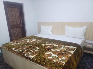 a bed in a room with a blanket on it at SnowCrest Cottage in Pahalgām