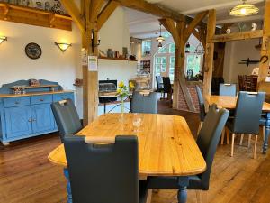 a dining room with a wooden table and chairs at Hotel TraumzeitHof in Eschede