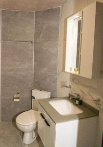 a bathroom with a toilet and a sink and a mirror at Хотел Терес in Kazanlŭk