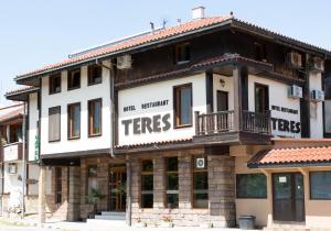a white building with the words trees on it at Хотел Терес in Kazanlŭk