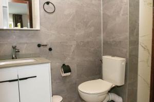 a bathroom with a white toilet and a sink at Хотел Терес in Kazanlŭk