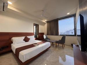 a hotel room with a bed and a tv at Hotel Aqua in Rajkot