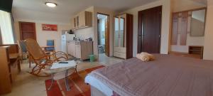 a bedroom with a bed and a table and a kitchen at Villa VértesKacsa in Vértesacsa