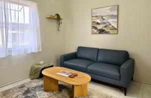 a living room with a blue couch and a table at Kimba Units - Better than a motel room - self contained and pet friendly in Kimba