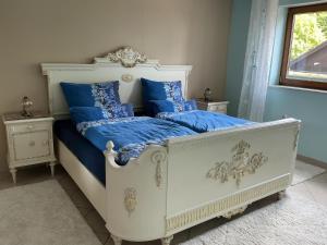 a bed with blue sheets and blue pillows on it at Zur Kapellenwiese in Oberthal