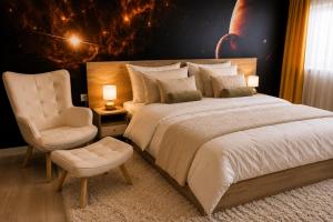 a bedroom with a large bed and a chair at Galaxy Apartments in Belgrade