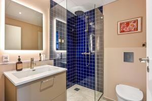 a bathroom with a sink and a shower with blue tiles at The Break Hotel in Herning +28 photos