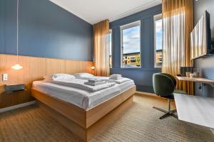 a bedroom with a bed and a desk and window at The Break Hotel in Herning