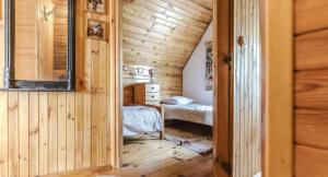 a bedroom in a log cabin with two beds at Domki na Olszynki in Okuninka