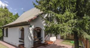 a small white building with a tree in front of it at Domki na Olszynki in Okuninka
