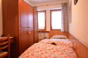 a small bedroom with a bed and a window at Cá Enrosadira Piano Secondo in San Vito di Cadore