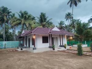 a small house with a purple roof at Ocean wings Traditional beach villa in Kaipamangalam
