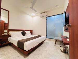 a bedroom with a bed and a glass door at Hotel Aqua in Rajkot