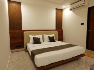 a bedroom with a large bed with two pillows at Hotel Aqua in Rajkot +11 photos