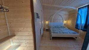 a small room with a bed in a wooden house at Camping Yoghi e Bubu in San Giacomo