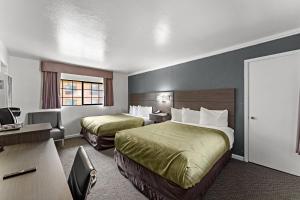 a hotel room with two beds and a desk at Econo Lodge Inn & Suites Heavenly Village Area in South Lake Tahoe