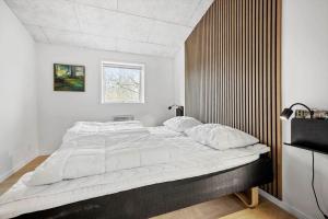 a bedroom with a large bed with a wooden headboard at SL343-Slagelse-Bygvangen-7 in Strandlyst