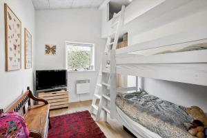 a bedroom with two bunk beds and a tv at SL343-Slagelse-Bygvangen-7 in Strandlyst