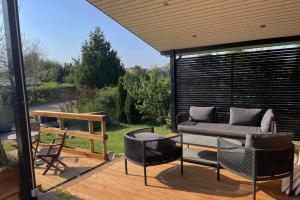 a patio with a couch and chairs on a deck at SL343-Slagelse-Bygvangen-7 in Strandlyst