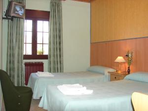 a hotel room with two beds and a window at Apartamentos Jucar - Hotel Rural in Tragacete +18 photos