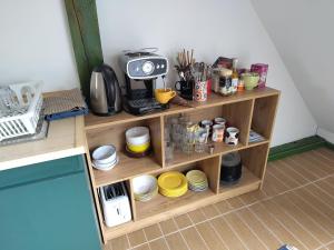 a kitchen shelf with a tv and some dishes at Mackó Kuckó Verőce in Kismaros