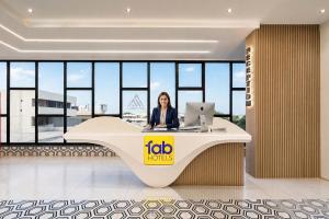 a woman sitting at a desk with a laptop at FabHotel A Square - 400m from Bhimavaram Junction in Bhīmavaram