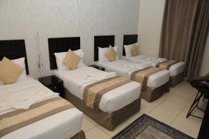 a group of four beds in a hotel room at كنوز العمر in Mecca