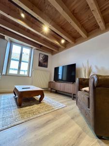 a living room with a couch and a tv at Cozy Apartment in Pontgibaud