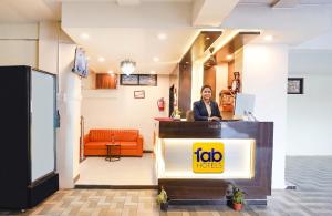 a woman standing at a podium in a lobby at FabHotel Sunrise Comforts in Pune