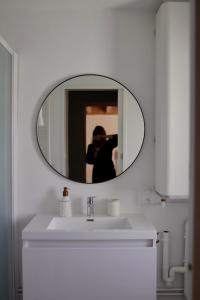 a person taking a picture of a mirror over a sink at Cozy Apartment in Pontgibaud +26 photos