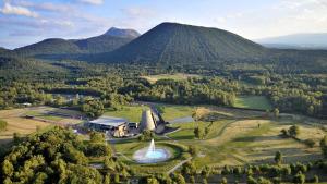 an aerial view of a farm with a fountain and mountains at Cozy Apartment in Pontgibaud