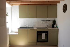 a kitchen with green cabinets and a stove at Cozy Apartment in Pontgibaud