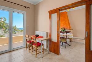 a dining room with a table and chairs and a window at Haris House in Dhaskalión