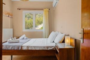 a bedroom with a bed and a window at Haris House in Dhaskalión