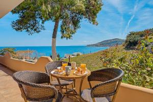 a table and chairs on a patio with a view of the ocean at Haris House in Dhaskalión