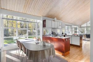 a large kitchen with a table and chairs in it at 6715-Hasle-Skovkanten-12 in Hasle